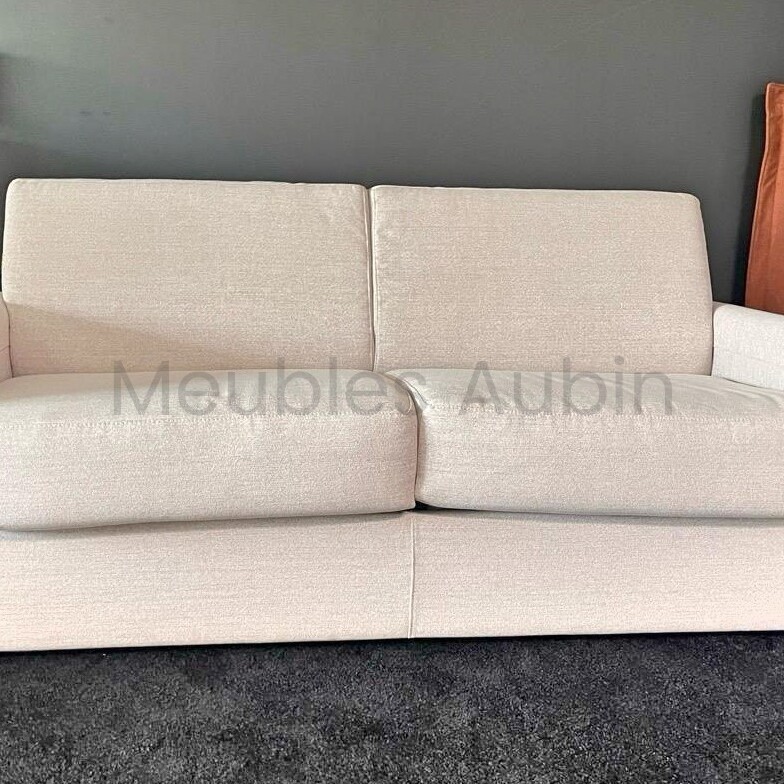 canape beige posé sur une moquette noire