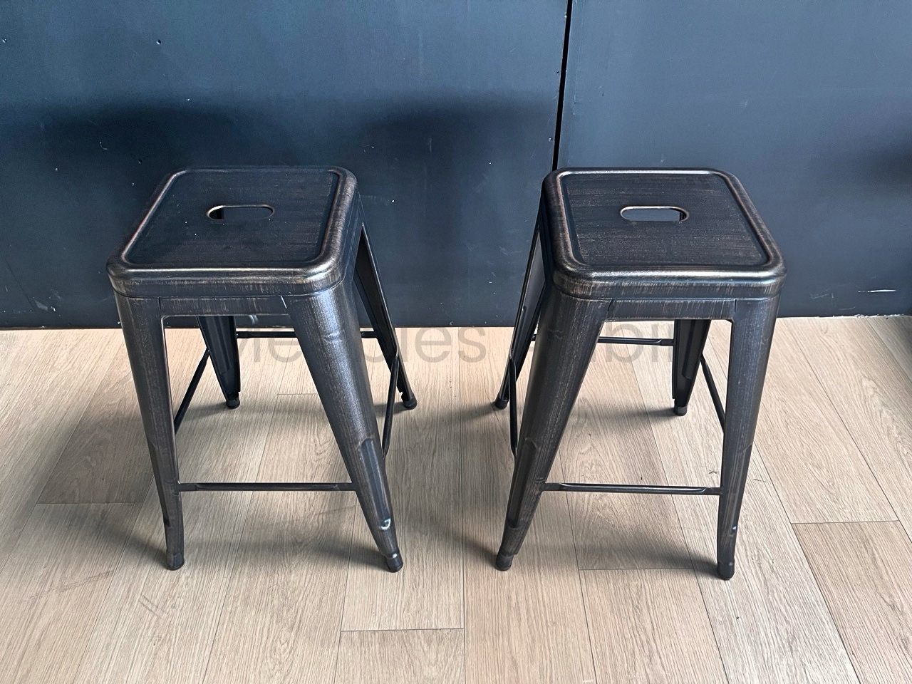 tabouret en metal noir, mur noir, parquet bois clair